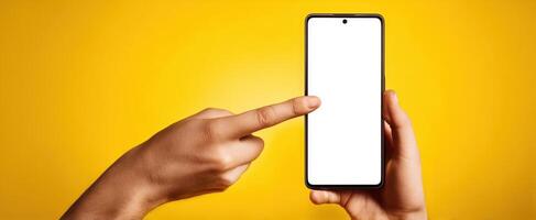 The smartphone with a blank screen held by hands against a vibrant yellow background. photo