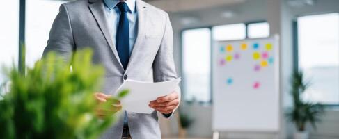 The businessman reviewing documents in a modern office setting with greenery. photo