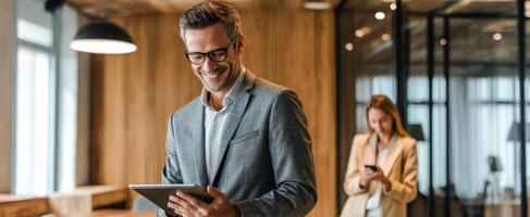 The confident businessman using a tablet while his colleague engages in conversation. photo