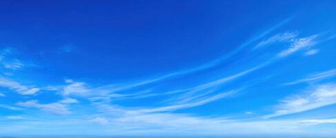 The serene blue sky with soft, wispy clouds hovering above the horizon. photo