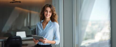 The confident woman with a tablet in a modern office setting. photo