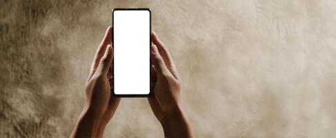 The smartphone held in hands against a soft textured background. photo