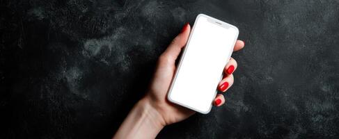The smartphone in a feminine hand on a dark textured background. photo