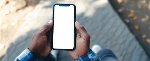 The smartphone held in hands against a blurred outdoor backdrop. photo