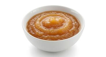 A bowl of apple sauce on a white surface photo
