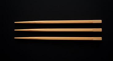 Three chopsticks on a black surface photo
