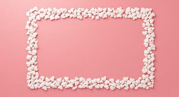 A square frame made of white pebbles on a pink background photo