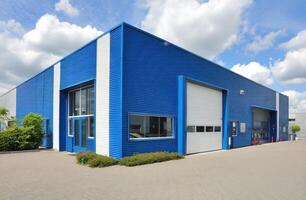 A Blue and White Warehouse Structure with Clouds in Sky for Commercial Use photo