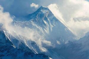The Majestic Beauty of a Snow Covered Mountain Peak and Cloudy Sky Above photo