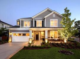 Beautiful Two Story Home With Open Garage Door and Green Lawn Space photo