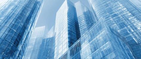 Cool Tall Blue Buildings With Glass Windows Under A Blue Sky View photo