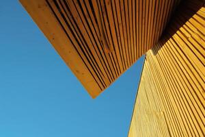 Abstract Geometric Wooden Structure Against Bright Blue Sky Background photo