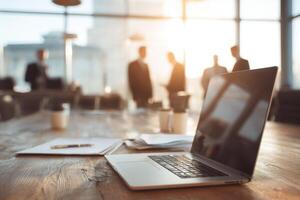 Laptop on a Conference Table with Business People Meeting in Background photo