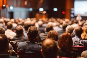 Large Group of People Sitting in a Room Watching a Presentation photo