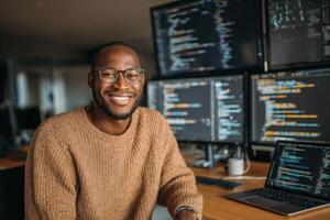 Smiling programmer working in modern office surrounded by multiple computer screens photo