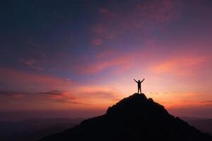 Silhouette of a person on a hilltop at sunrise or sunset photo