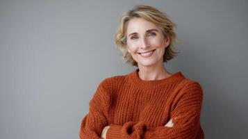 Portrait Of A Beautiful Mature Woman Standing And Smiling On Gray Background photo