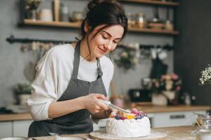 A Baker Prepares Cake Topping Adding Fruit Finishing Touches in the Kitchen photo