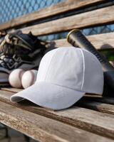 White Baseball Cap on a Bench with Baseball Bat and Accessories photo