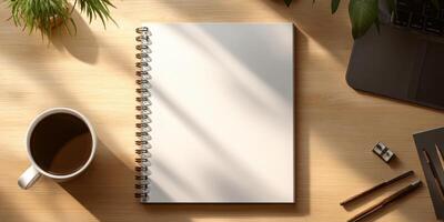 A Workplace Desktop Notebook with Coffee Cup and Plant in Natural Light photo