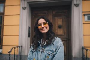 A Young Woman Posing in Front of Antique Door With Yellow Glasses photo