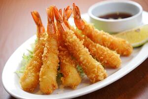 A plate of fried shrimp with a dipping sauce photo
