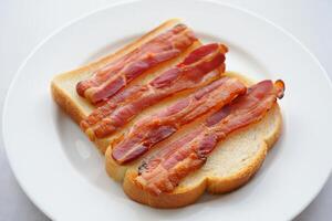 A slice of bacon on a piece of bread photo