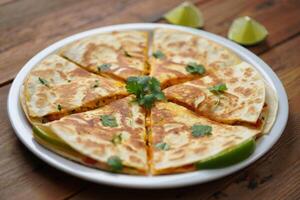 A quesadilla with cheese, cilantro and lime photo