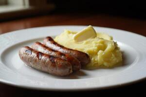 A plate with two sausages and mashed potatoes on it photo