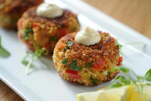 A plate with three crab cakes on it photo