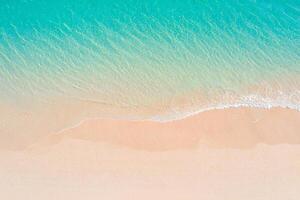 Beach Background Aerial View of Turquoise Ocean Waves Gently Crashing on a Pink Sandy Beach photo