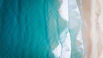 Beach Background Wallpaper Top View of Turquoise Ocean Waves Crashing on Pristine Sandy Beach photo