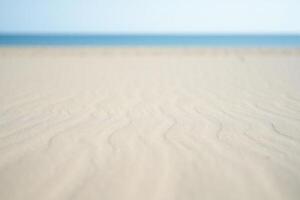 Beach Background Serene Beach Scene Soft Sand Texture with Blurred Ocean Background photo