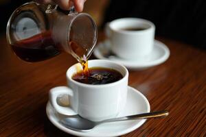 Coffee Background Pouring Freshly Brewed Coffee into White Cups on Wooden Table photo
