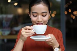 Coffee Background Young Asian Woman Enjoying a Warm Coffee Drink in a Cafe Setting photo