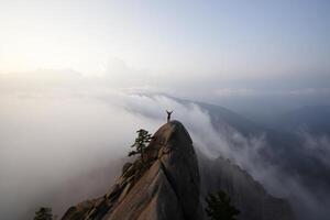 Nature Background Adventurous Hiker Triumphantly Standing on Mountain Peak Above Cloudscape photo