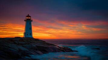 Peggy's Cove lighthouse stands tall against a beautiful sunset at the edge of the ocean photo