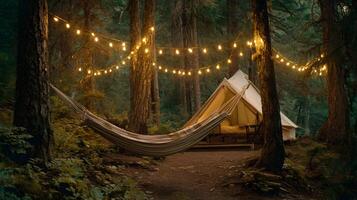 Cozy campsite featuring a canvas tent and hammock nestled among the trees lit by string lights photo