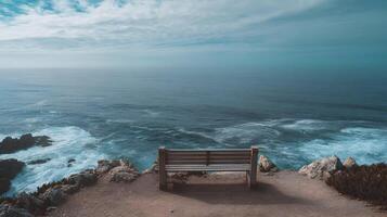 A peaceful wooden bench overlooks the vast and calming ocean under a sky full of soft clouds photo
