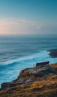 Seaside serenity captures the essence of tranquility with a solitary bench overlooking the vast ocean expanse photo