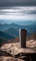 Stainless steel tumbler enjoying an overlook view of a beautiful mountain range landscape photo