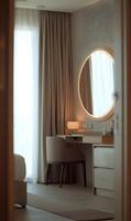 Elegant dressing table in a modern bedroom bathed in soft light creating a serene atmosphere photo