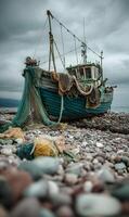 Abandoned fishing boat stranded on pebble beach under a dramatic cloudy sky creating moody atmosphere photo