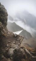 Paper Airplane on a Cliff Edge Symbolizing Freedom Hope and Adventure Against Mountain Backdrop photo