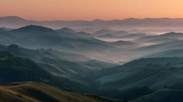 Majestic mountain range shrouded in a gentle morning mist illuminated by the warm glow of sunrise photo
