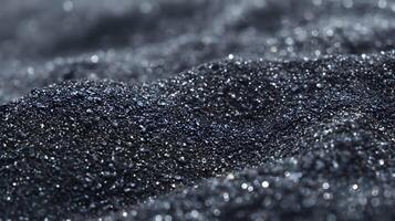 An abstract background image showcasing undulating heaps of dark shimmering material under soft illumination photo