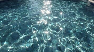 Sunlight dances on the surface of clear blue water creating mesmerizing patterns and reflections, offering a refreshing and calming view photo