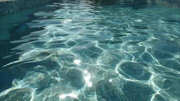 Sunlight dances on the clear turquoise water surface creating mesmerizing patterns on tiled pool floor photo