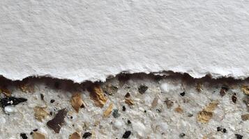 Abstract image showing a torn sheet of white paper against a textured surface with embedded material photo