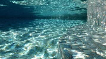 Underwater view of a swimming pool shows light filtering through the surface casting patterns below photo